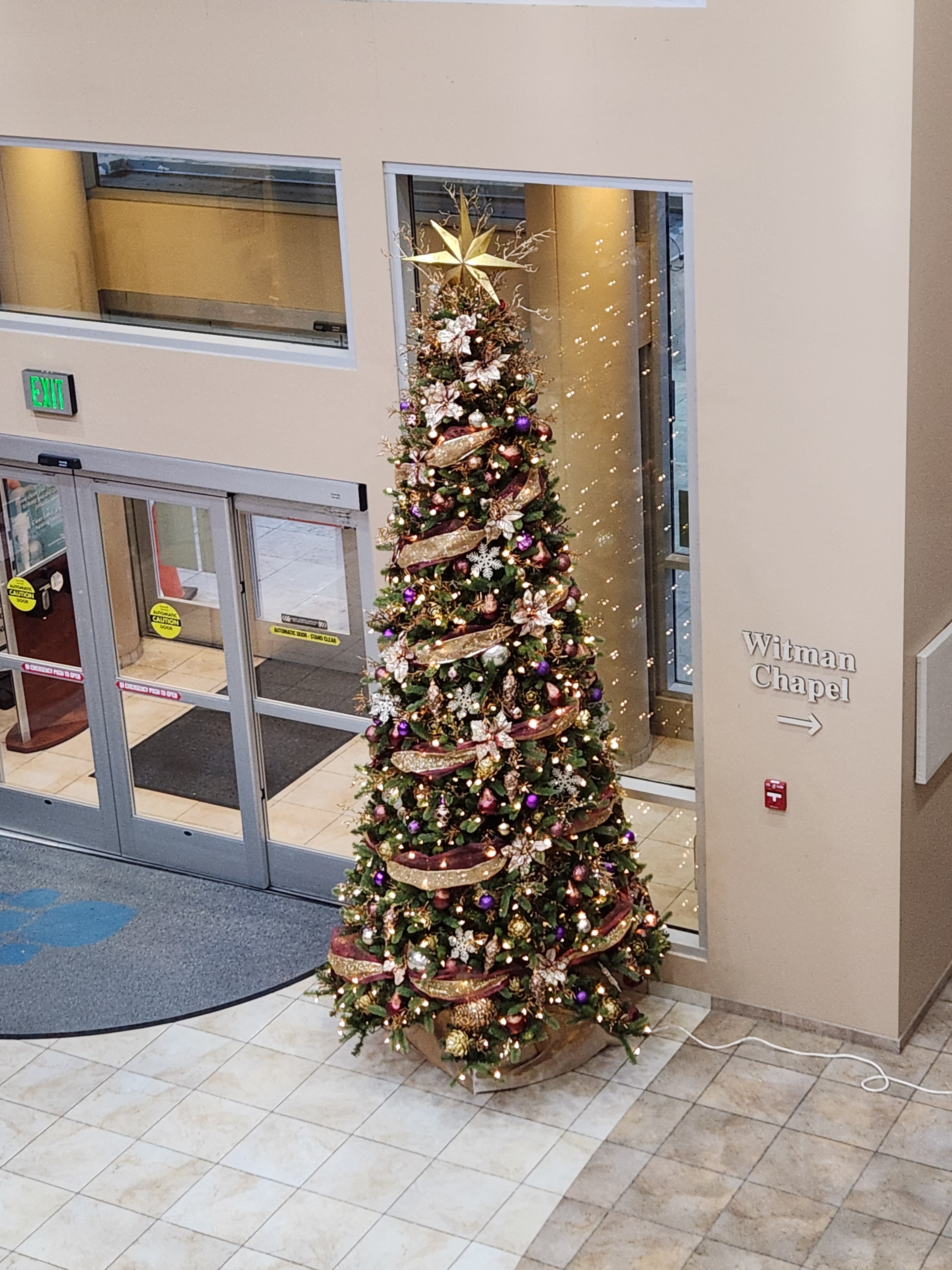 Witman Chapel entrance with lush Christmas garland in purple, gold and white with star topper