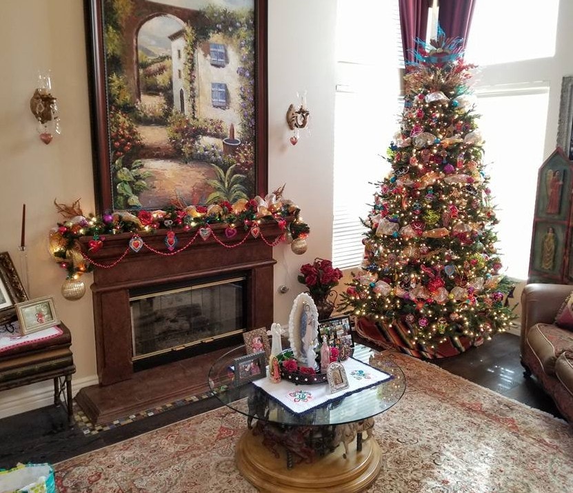 Living room with colorful Christmas tree, garland-adorned fireplace and large oil painting above mantel