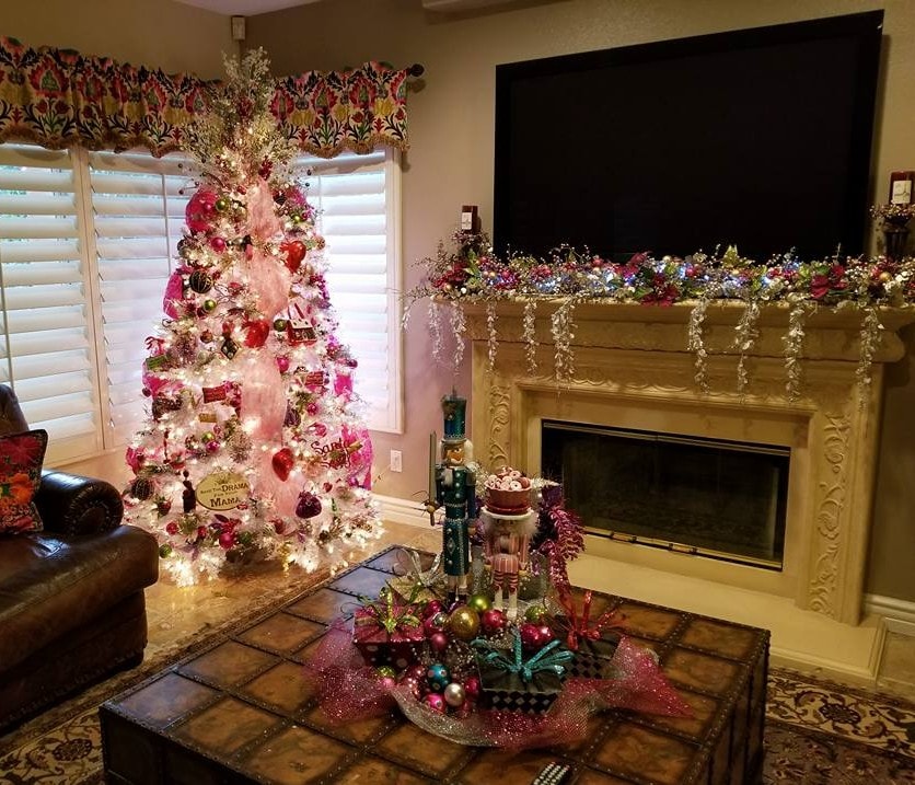 Pink flocked Christmas tree with nutcracker centerpiece and garland-draped fireplace mantel