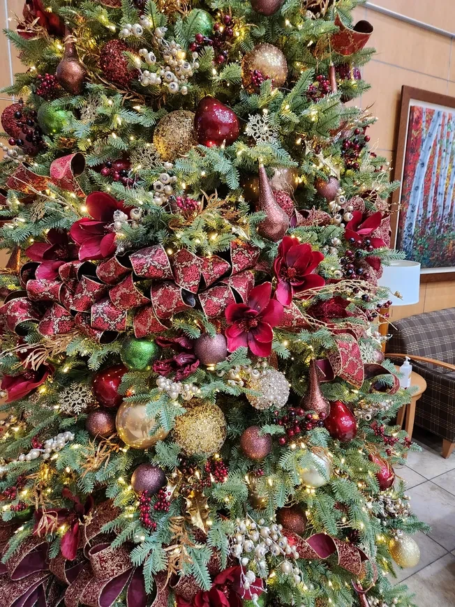 Decorated Christmas tree with burgundy ornaments and flowers